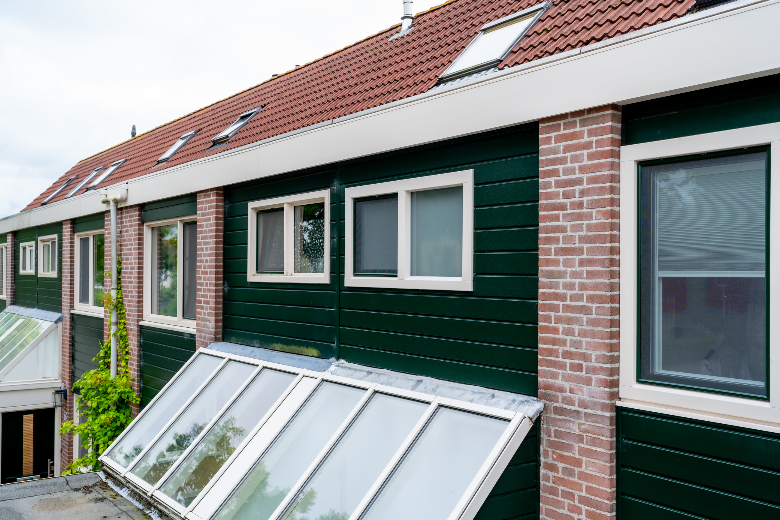 Groene Keralit gevelbekleding en aluminium lichtstraat in Alkmaar